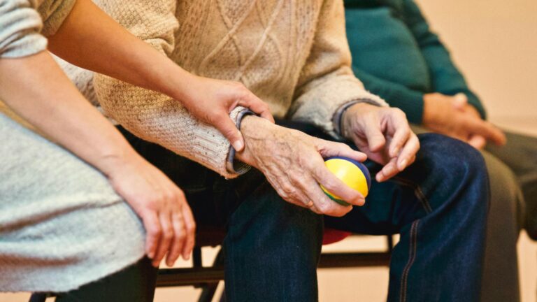 Two elderly people holding hands.